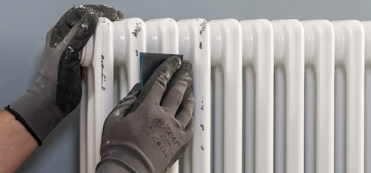 Der Heizkörper wird vor dem Lackieren angeschliffen 