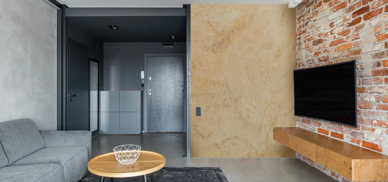 Wohnzimmer mit einer mit Calce Argilla verputzen Wand im Hintergrund