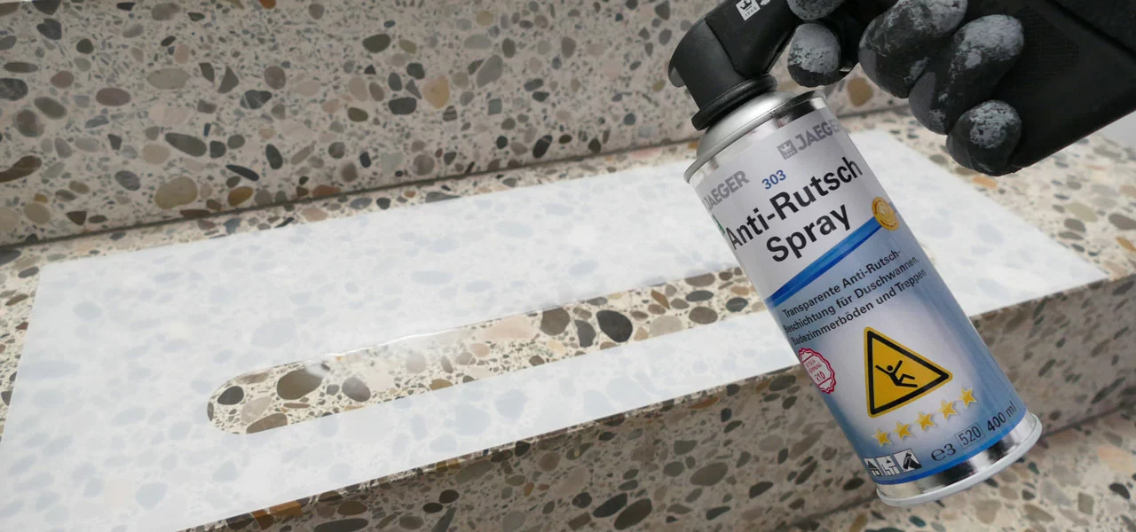 Person besprüht eine Treppenstufe mit einem Anti-Rutsch Spray und einer Anti-Rutsch Schablone 