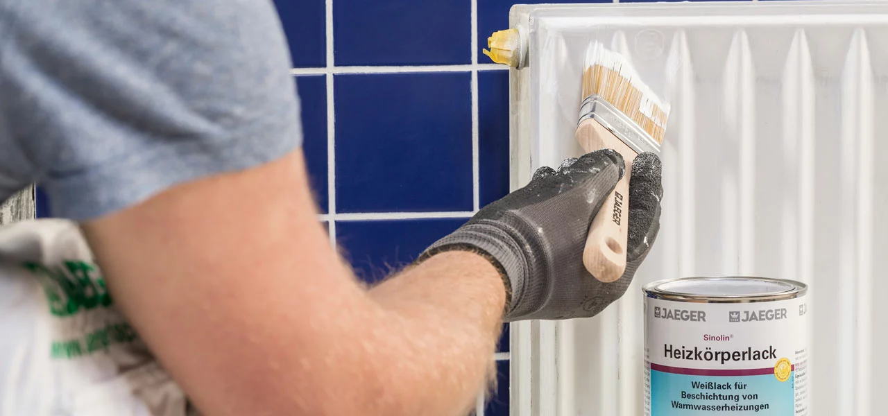Heizkörperlack wird auf einen weißen Heizkörper gestrichen