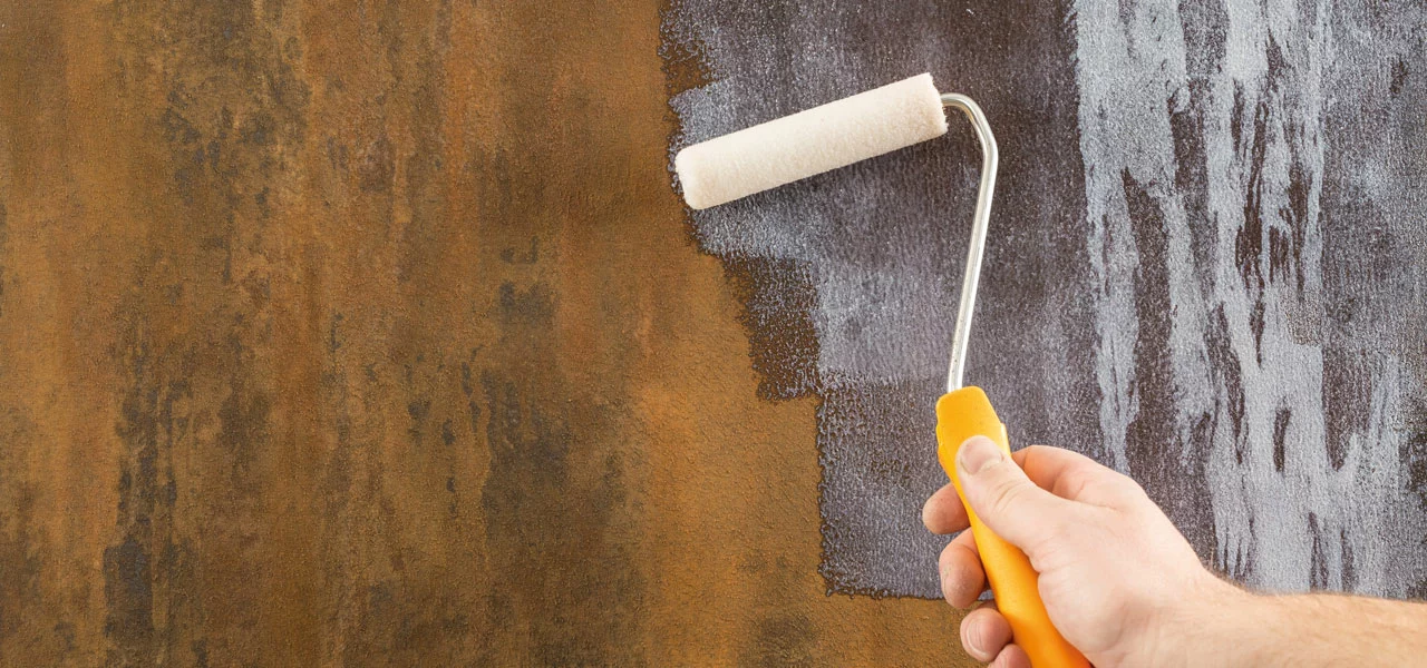 Über die Rostfarbe wird ein Siegel mit einer Walze gestrichen