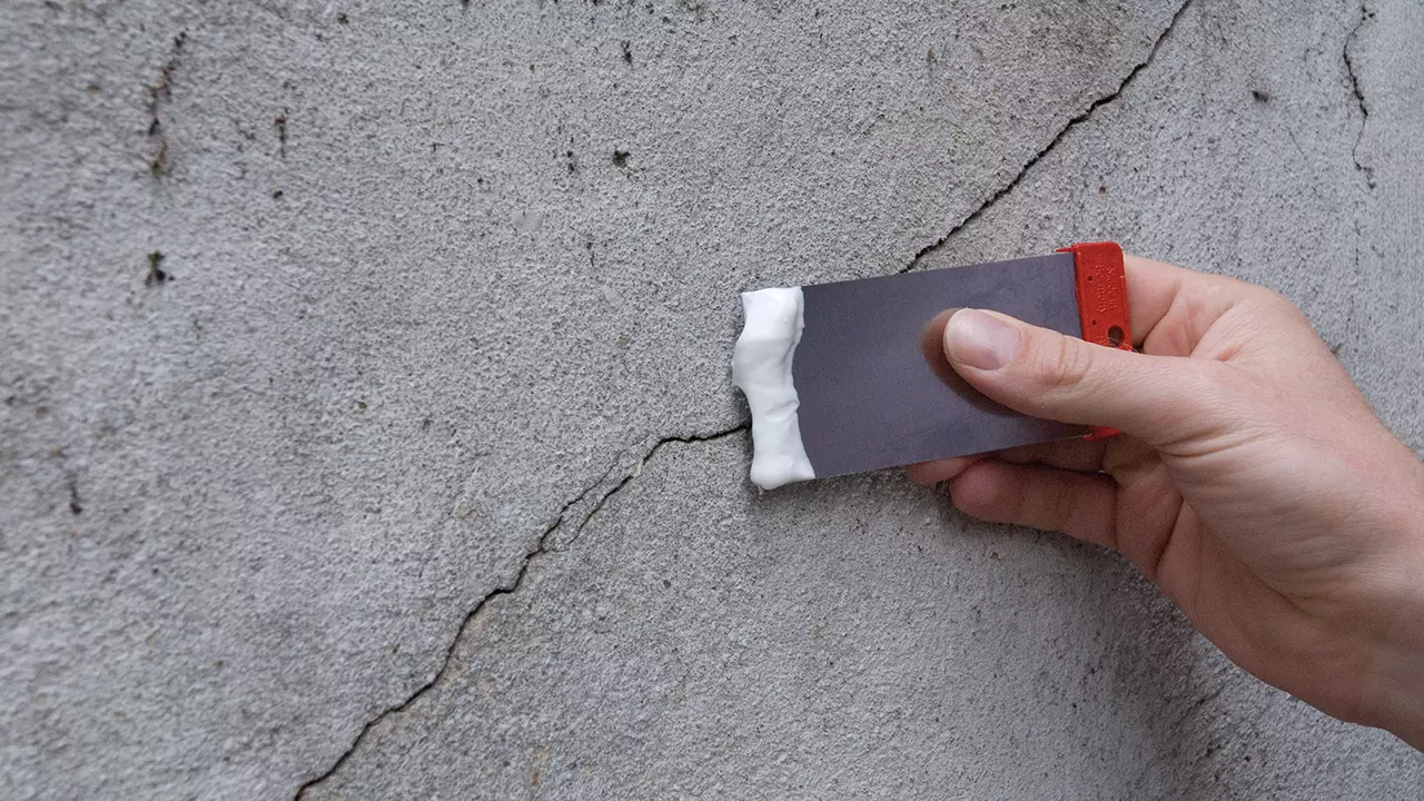 Person trägt mit einer Japanspachtel die Füll-und Feinspachtelmasse von Jaeger auf.