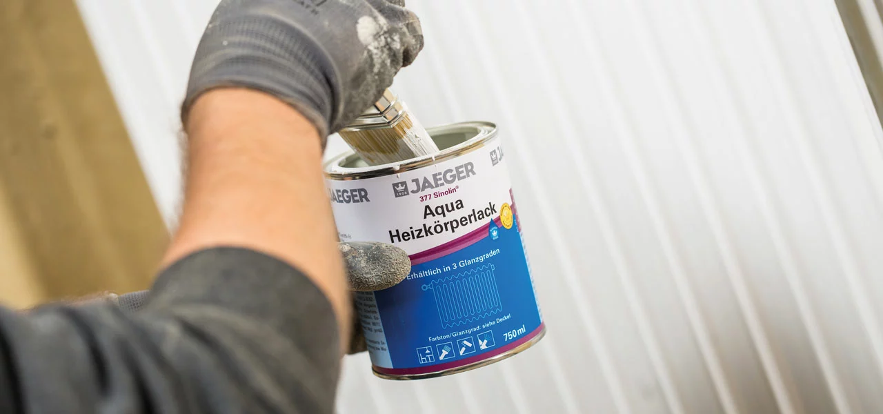 Heizkörperlack wird mir einem Pinsel aufgetragen