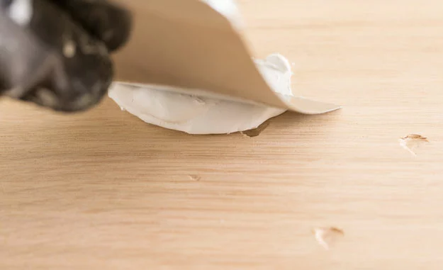 Macken im Holz werden mit einer Spachtelmasse geglättet