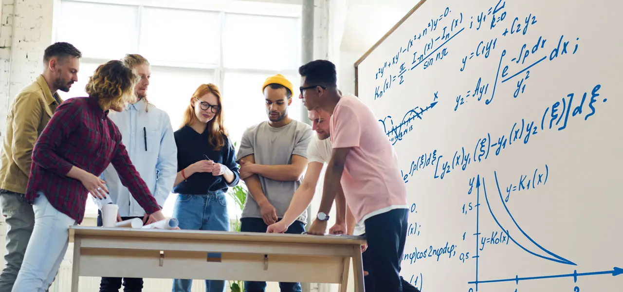 Personen während einer Besprechung, die vor einem Whiteboard stehen