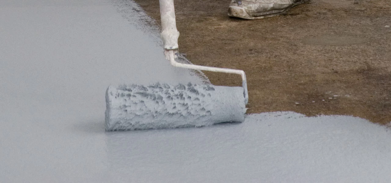 Boden, der mit einer Farbwalze mit der Bodenbeschichtung gestrichen wird.