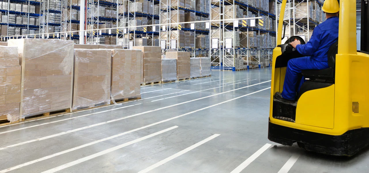 Lagerhalle mit Gabelstapler und einer Linienmarkierung am Boden 