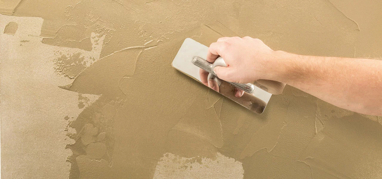 Wand wird mit einer Traufel geglättet 