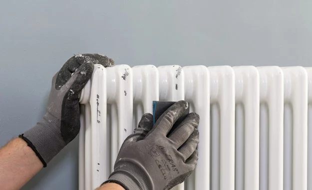 Der Heizkörper wird vor dem Streichen angeschliffen