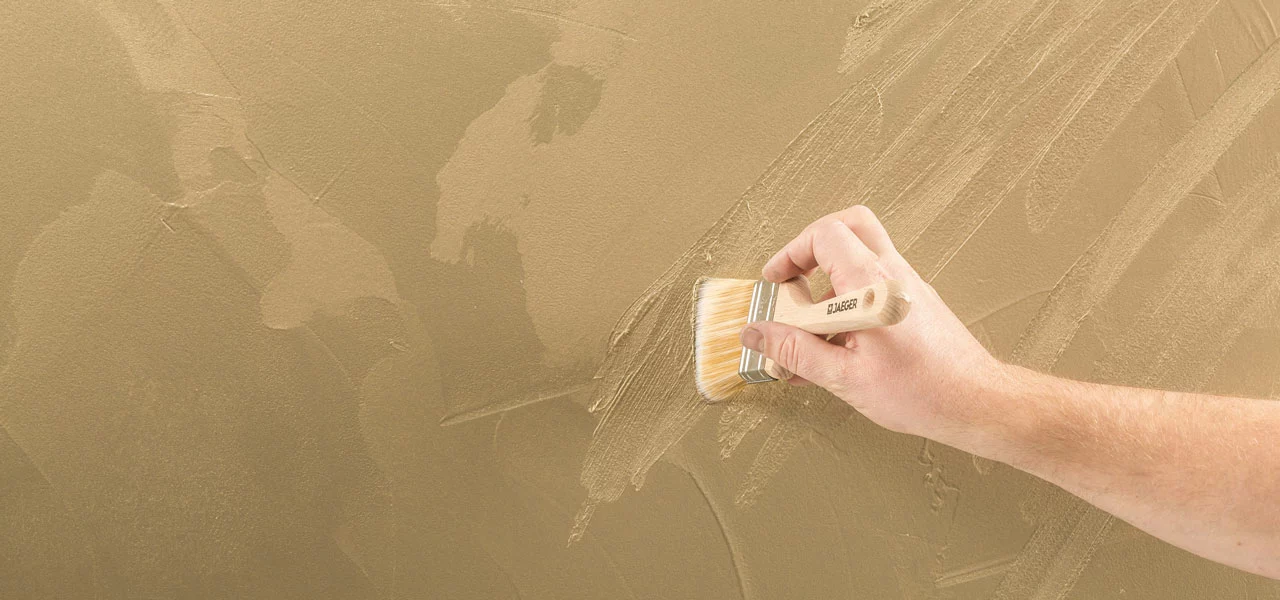 goldene Fläche wird mit einem Pinsel strukturiert