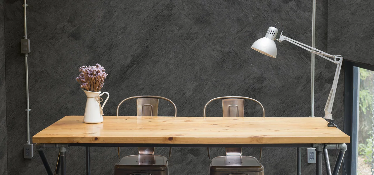 Esszimmertisch mit einer metallischen Wand im Hintergrund